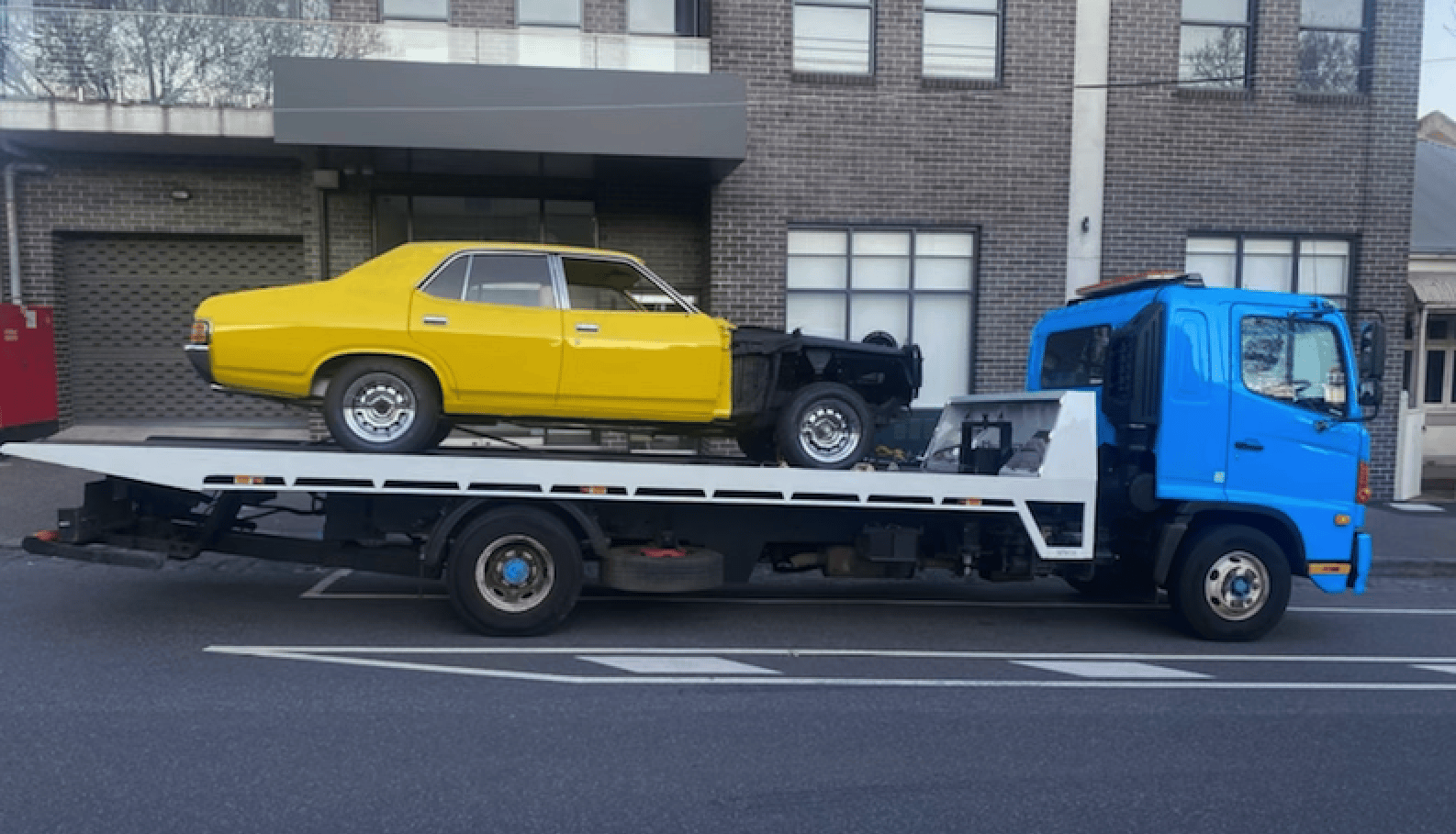 A car body being removed on a busy Melbourne street.